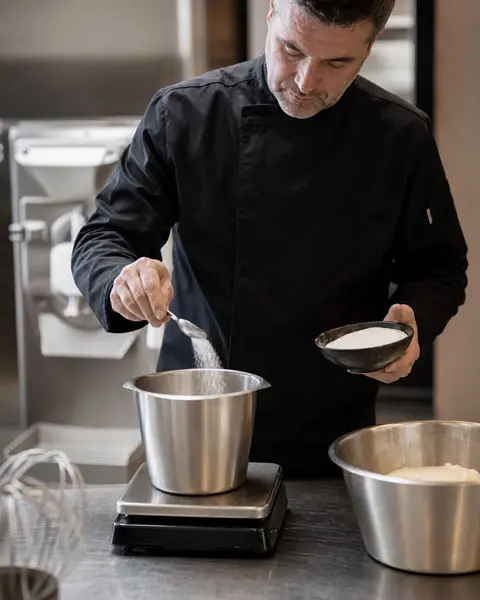 Maestro heladero preparando una receta en un obrador profesional